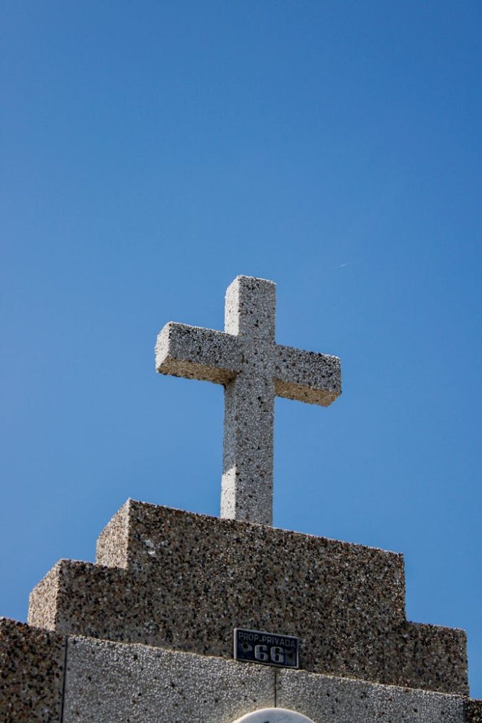 Simple stone cross on a structure with clear blue sky backdrop in Santa Marta, Colombia.